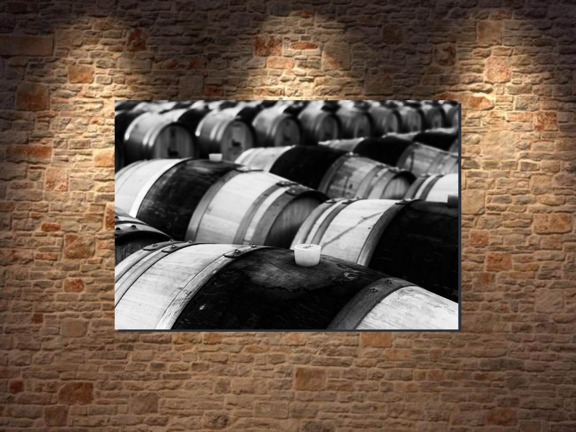 Black and white photo of wine barrels on a brick wall giving a beautiful voice and style to the wall.