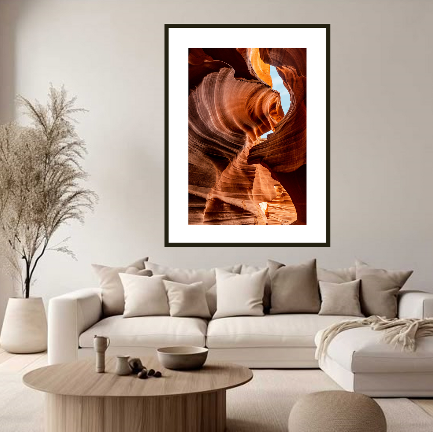 Framed artwork of a canyon wall above a living room sofa.