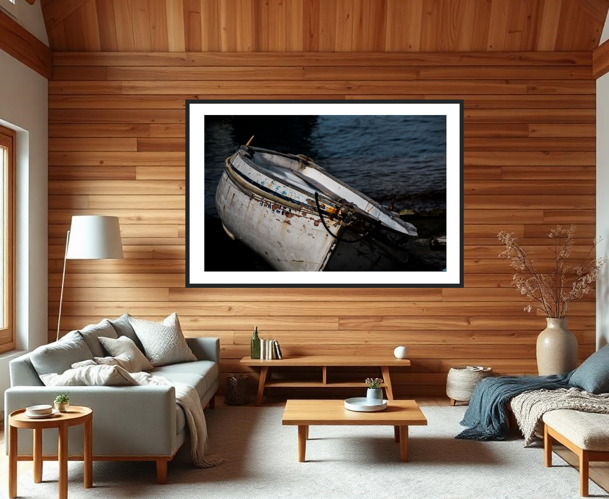 Living room with a framed photograph of a boat on the wall, wooden floor, and furniture.