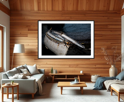 Living room with a framed photograph of a boat on the wall, wooden floor, and furniture.