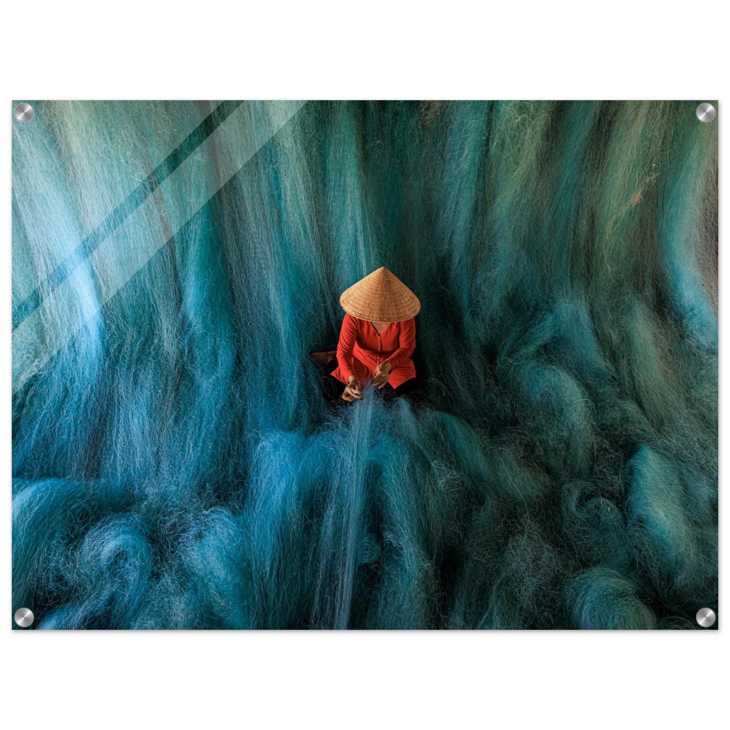 Person in a red outfit and straw hat sitting amidst large blue lines of cotton that simulates a beautifull green-blue waterfall, printed in acrylic.