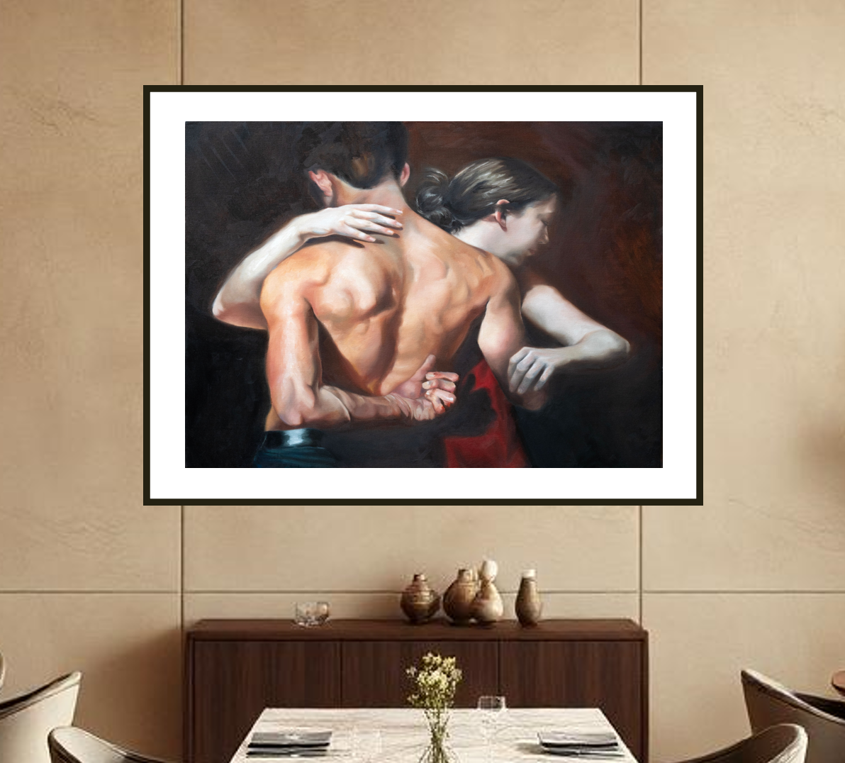 Framed painting of a couple embracing on a wall above a dining table.