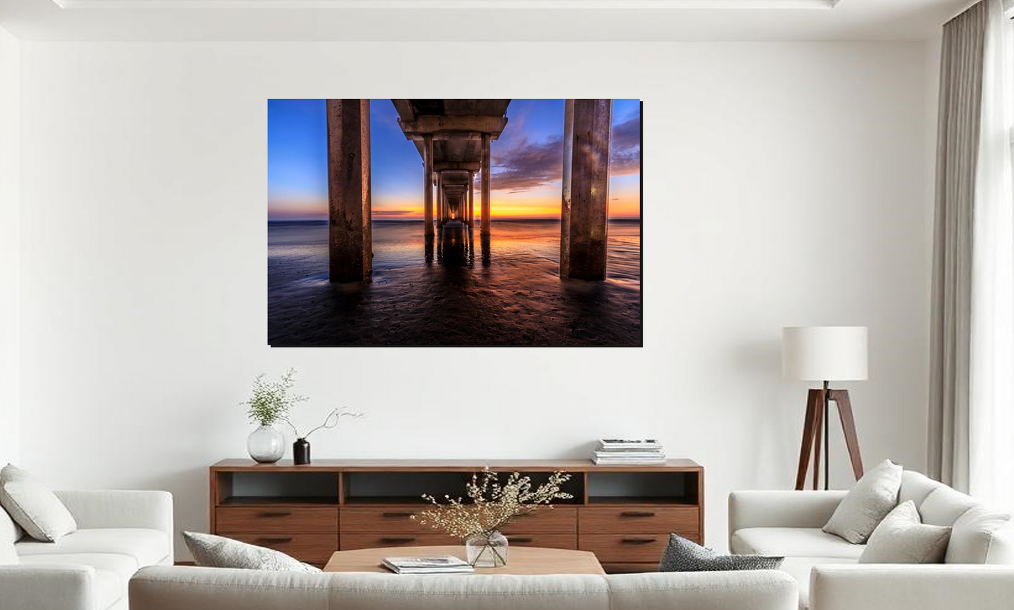 Living room with a large TV displaying a sunset under a pier, white walls, and a window.