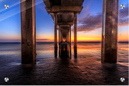 Sunset under a pier with water reflections