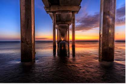 Sunset view under a pier with water reflections