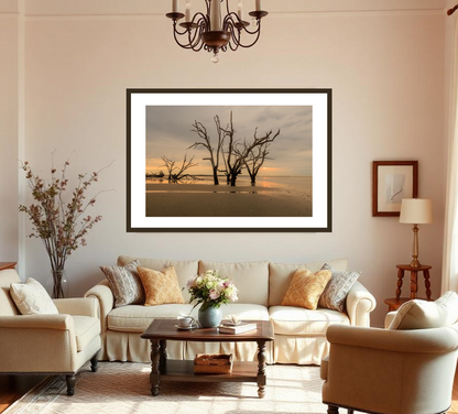 Living room with beige sofa, armchair, and coffee table, featuring a framed beach scene on the wall.