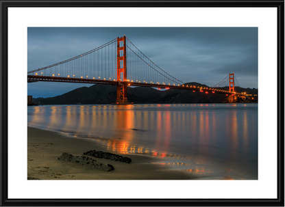 Framed photograph of the Golden Gate Bridge at dusk with reflection on water.