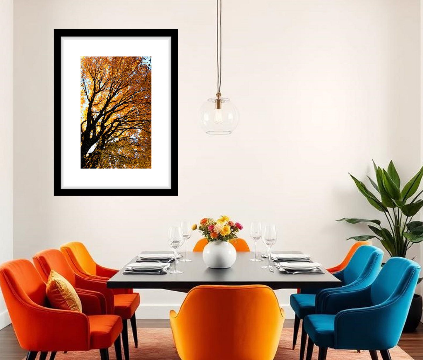 Modern dining room with colorful chairs and a framed autumn tree picture on the wall.
