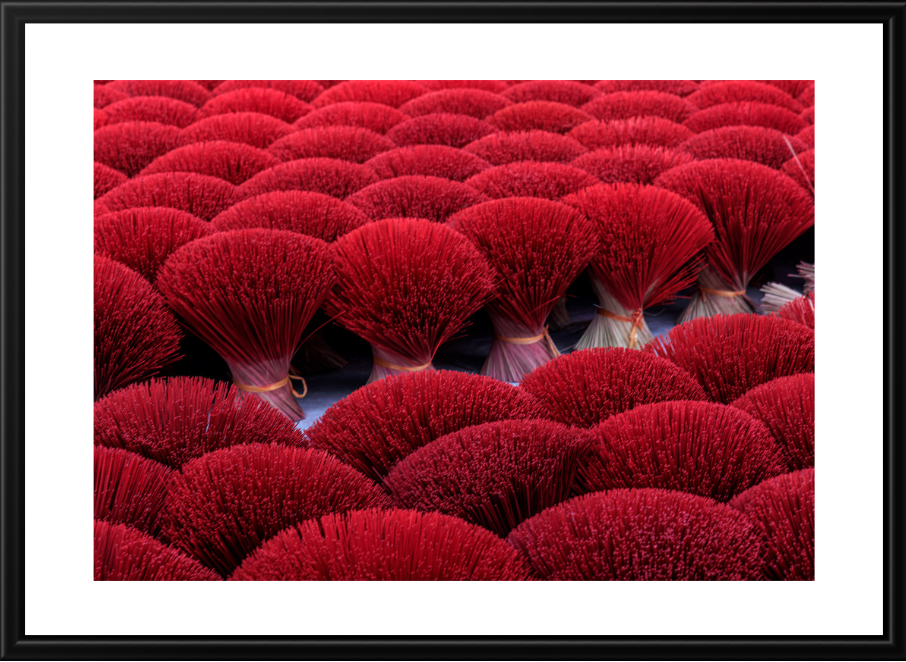 Close-up of red incense sticks in a patterned arrangement.