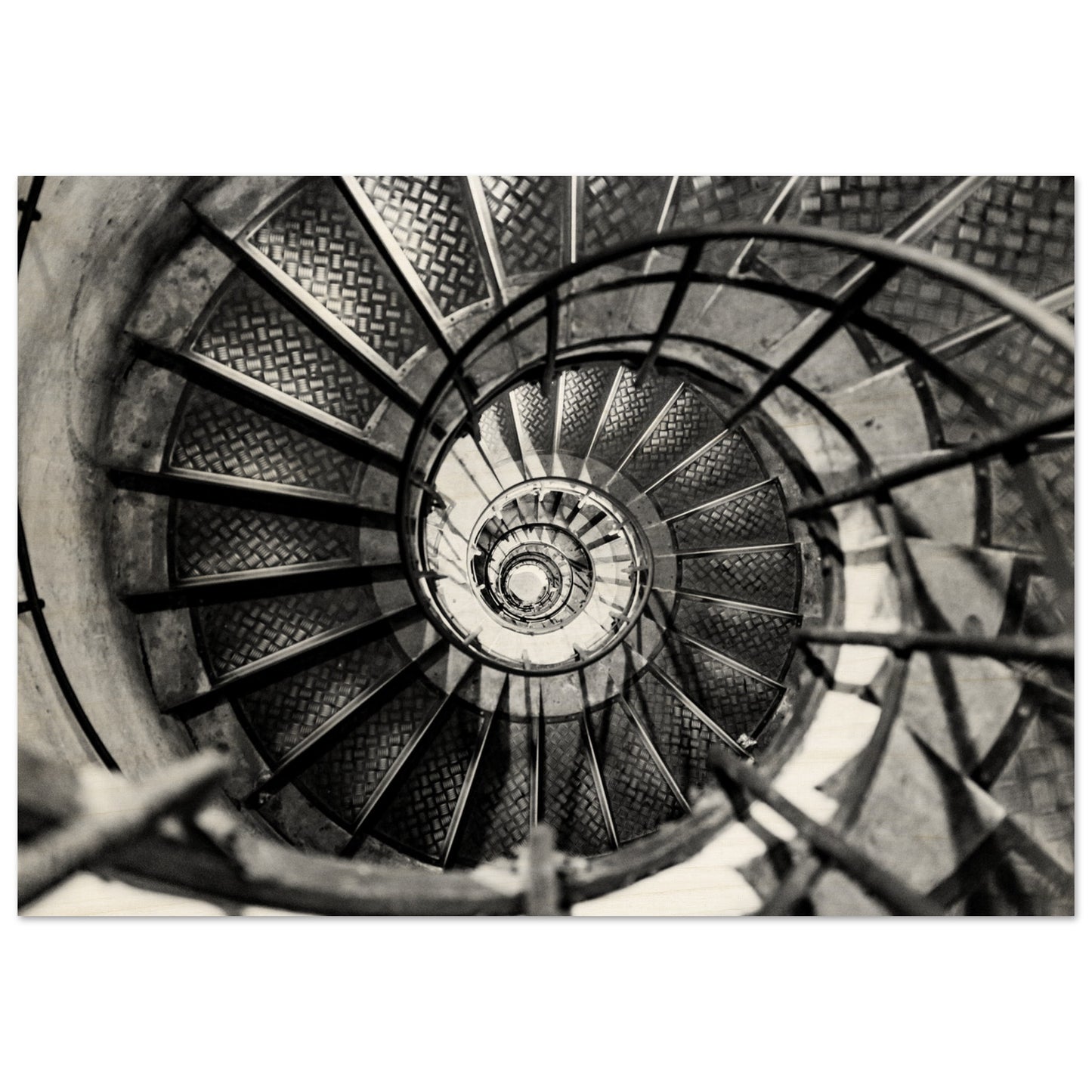 A Black and white photography of an  elegant spiral staircase. High-end wood printing.