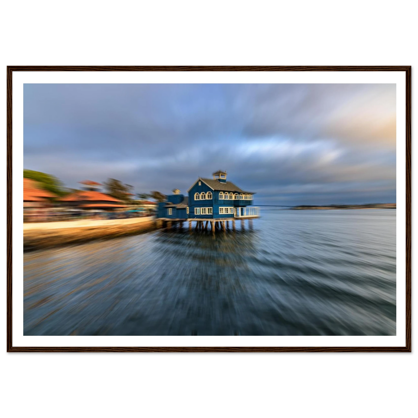 Blue house on stilts over water with a blurred foreground, framed picture.