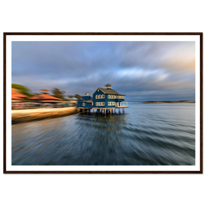 Blue house on stilts over water with a blurred foreground, framed picture.