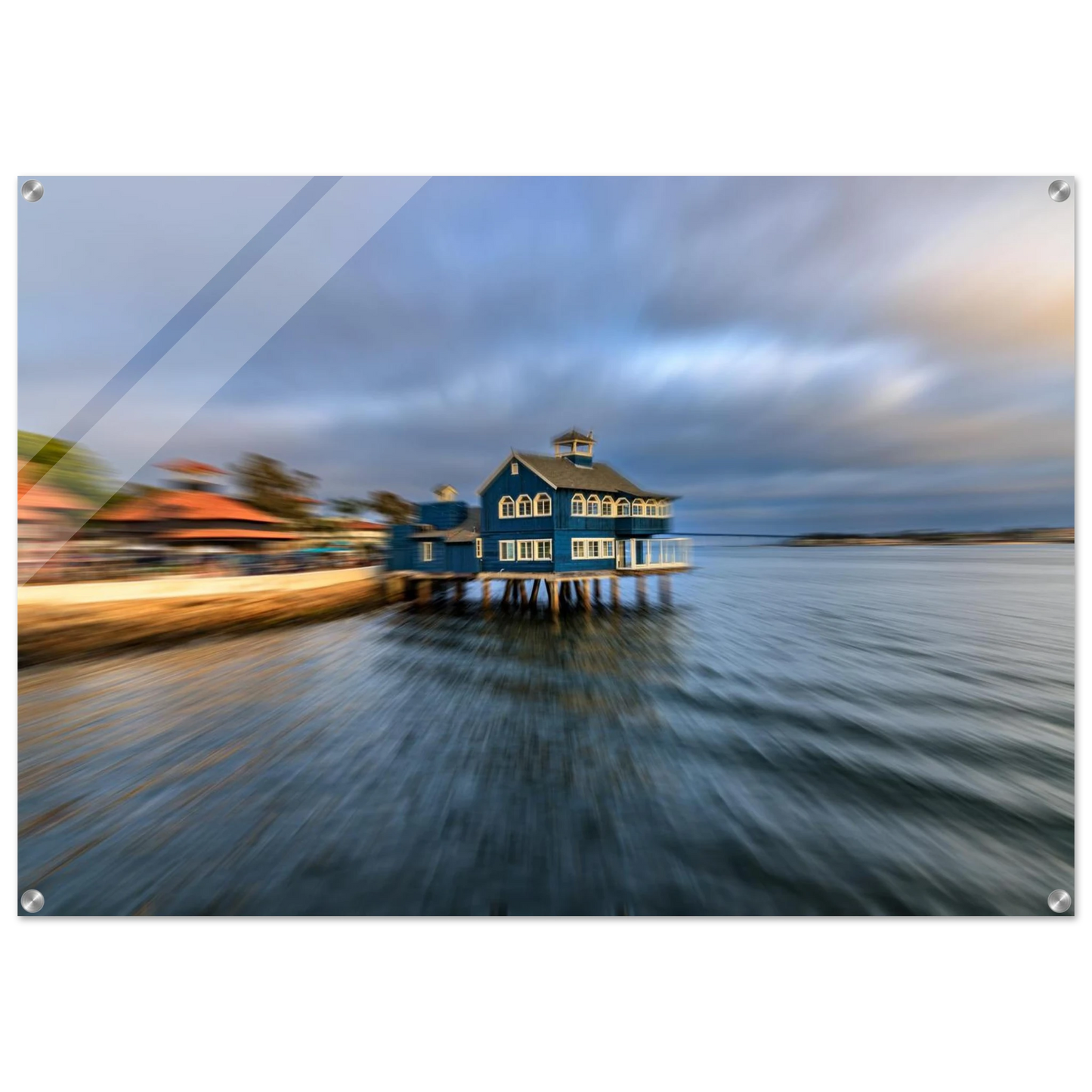 Blue house on stilts over water with a blurred foreground printed in high-quality acrylic.