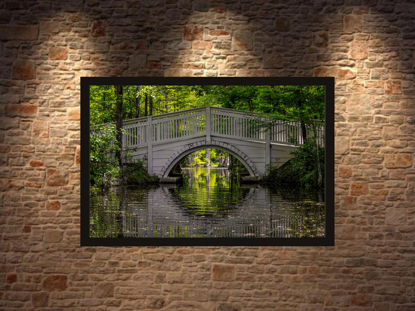 Framed photograph of a bridge over water on a brick wall. Fine quality paper and frame, ideal for minimalist modern or rustic spaces.